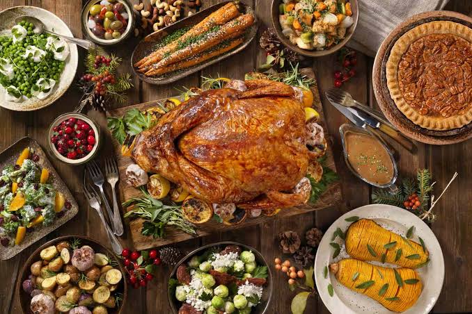 Photo of a Thanksgiving dinner complete with turkey and many side dishes.